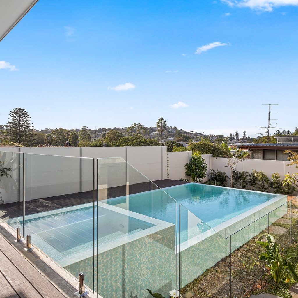 A well-maintained backyard pool with clear blue water, emphasising the importance of pool safety features like fencing and covers in the Illawarra region.